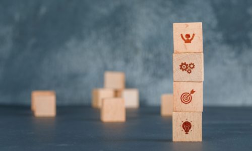 Conceptual of business with wooden blocks column with icons on dark color background side view. free space for your text horizontal image